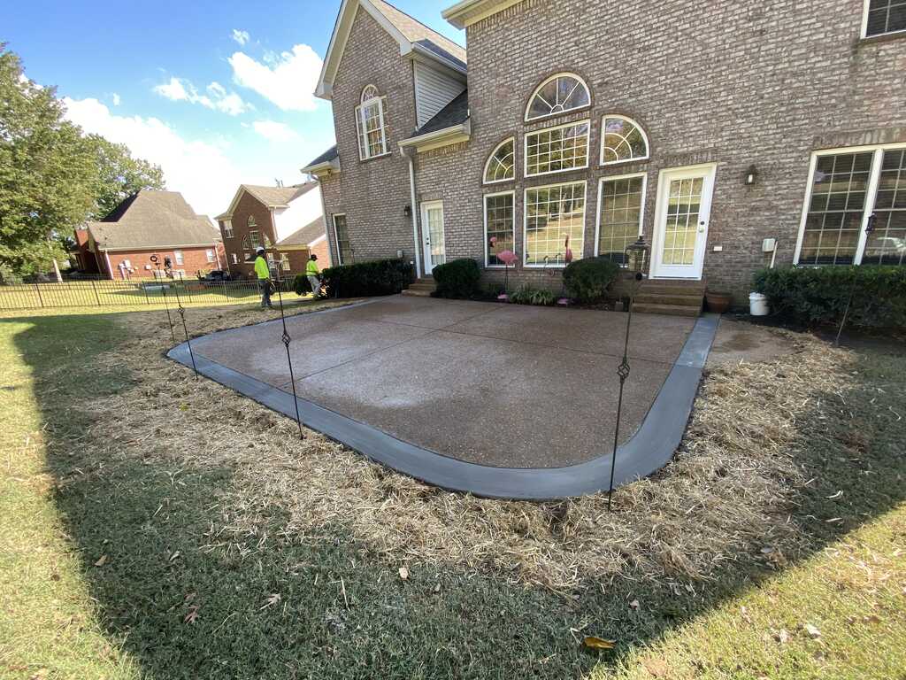 Finished concrete patio surface behind a brick home